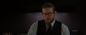 Movie still from “The Gentlemen” (2019), directed by Guy Ritchie – A man with a beard wearing a suit and tie; Close Up shot, Low angle