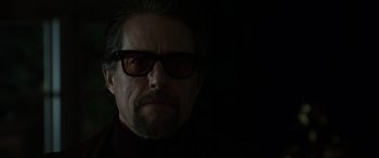 Movie still from “The Gentlemen” (2019), directed by Guy Ritchie – A person wearing glasses; Close Up shot, Low angle