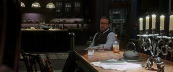 Movie still from “The Gentlemen” (2019), directed by Guy Ritchie – A man sitting at a table in a restaurant; Medium shot, Over the shoulder angle