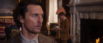 Movie still from “The Gentlemen” (2019), directed by Guy Ritchie – A man in a brown suit and a man in a brown suit; Close Up shot, Over the shoulder angle