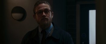 Movie still from “The Gentlemen” (2019), directed by Guy Ritchie – A man with a goatee wearing glasses and a tie; Close Up shot, Over the shoulder angle