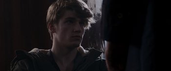 Movie still from “The Gentlemen” (2019), directed by Guy Ritchie – A young man looking at the camera while standing in front of a mirror; Close Up shot, Over the shoulder angle