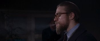 Movie still from “The Gentlemen” (2019), directed by Guy Ritchie – A man with a long beard wearing glasses; Close Up shot, Over the shoulder angle
