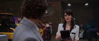 Movie still from “The Gentlemen” (2019), directed by Guy Ritchie – A man and a woman standing next to each other holding a laptop computer; Medium shot, Over the shoulder angle