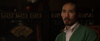 Movie still from “The Gentlemen” (2019), directed by Guy Ritchie – A person wearing a green shirt; Close Up shot, Over the shoulder angle