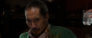 Movie still from “The Gentlemen” (2019), directed by Guy Ritchie – A person wearing a green jacket; Close Up shot, Low angle