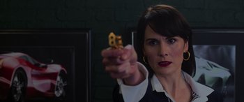 Movie still from “The Gentlemen” (2019), directed by Guy Ritchie – A woman is holding a small house in her hand; Close Up shot, Over the shoulder angle