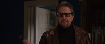 Movie still from “The Gentlemen” (2019), directed by Guy Ritchie – A person wearing glasses and a leather jacket; Close Up shot, Over the shoulder angle