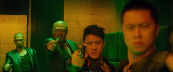 Movie still from “Deadpool 2” (2018), directed by David Leitch – A man holding a gun in front of another man; Medium shot, Low angle