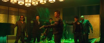 Movie still from “Deadpool 2” (2018), directed by David Leitch – A group of men playing a game of pong in a green room; Wide shot, Over the shoulder angle