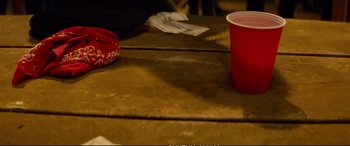 Movie still from “Deadpool 2” (2018), directed by David Leitch – A red cup on the table next to a bag; Close Up shot, High angle