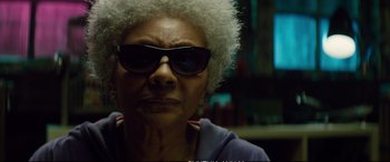 Movie still from “Deadpool 2” (2018), directed by David Leitch – An older woman wearing sunglasses and a purple jacket; Close Up shot, Low angle
