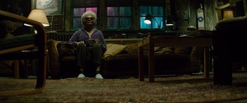 Movie still from “Deadpool 2” (2018), directed by David Leitch – An older woman sitting on the floor of a living room; Wide shot, Low angle