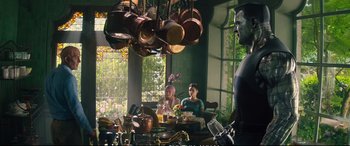 Movie still from “Deadpool 2” (2018), directed by David Leitch – A group of people sitting at a table in a kitchen; Wide shot, Over the shoulder angle