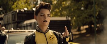 Movie still from “Deadpool 2” (2018), directed by David Leitch – A person in a yellow and black costume; Close Up shot, Over the shoulder angle