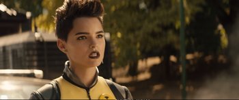 Movie still from “Deadpool 2” (2018), directed by David Leitch – A person wearing a yellow and black outfit; Close Up shot, Over the shoulder angle