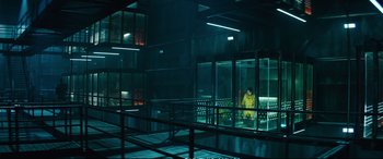 Movie still from “Deadpool 2” (2018), directed by David Leitch – A man in a yellow raincoat is in a room with glass walls; Extreme Wide shot, Low angle