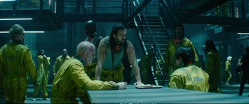 Movie still from “Deadpool 2” (2018), directed by David Leitch – A group of men sitting around a table; Medium shot, Over the shoulder angle