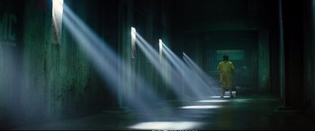 Movie still from “Deadpool 2” (2018), directed by David Leitch – A man in a yellow suit is standing in a room with beams of light shining through the windows; Extreme Wide shot, Low angle