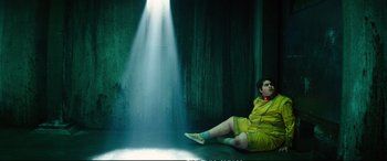 Movie still from “Deadpool 2” (2018), directed by David Leitch – A woman sitting on the ground in front of a light; Wide shot, Low angle