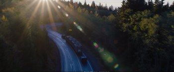 Movie still from “Deadpool 2” (2018), directed by David Leitch – A truck driving down a road near a forest filled with tall trees; Extreme Wide shot, Low angle