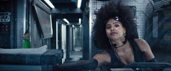 Movie still from “Deadpool 2” (2018), directed by David Leitch – A woman with a large black afro in a train station; Close Up shot, Low angle