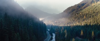 Movie still from “Deadpool 2” (2018), directed by David Leitch – A train traveling through a valley filled with trees; Extreme Wide shot, High angle