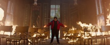 Movie still from “Deadpool 2” (2018), directed by David Leitch – A man standing in front of a burning building; Wide shot, High angle