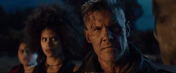 Movie still from “Deadpool 2” (2018), directed by David Leitch – A person with a person in the background; Close Up shot, Low angle