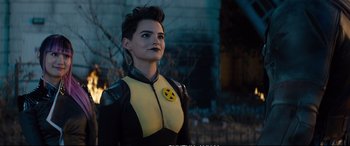 Movie still from “Deadpool 2” (2018), directed by David Leitch – A woman in a yellow and black costume looking to her left; Close Up shot, Over the shoulder angle