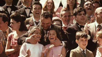 Movie still from “The Godfather” (1972), directed by Francis Ford Coppola – A group of people standing next to each other holding wine glasses; Close Up shot, Over the shoulder angle