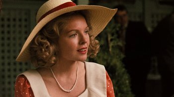 Movie still from “The Godfather” (1972), directed by Francis Ford Coppola – A woman wearing a straw hat and a red and white polka dot dress; Close Up shot, Over the shoulder angle