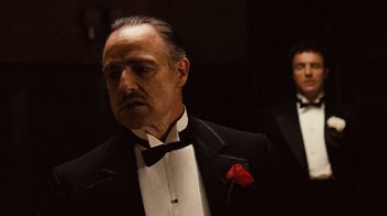 Movie still from “The Godfather” (1972), directed by Francis Ford Coppola – A man in a suit and a bow tie in front of another man in a suit and a bow tie; Medium shot, Over the shoulder angle