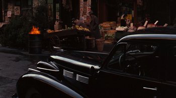 Movie still from “The Godfather” (1972), directed by Francis Ford Coppola – An old car parked on the side of the street; Wide shot, High angle