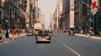 Movie still from “The Godfather” (1972), directed by Francis Ford Coppola – Cars driving down a street in a city; Extreme Wide shot, High angle
