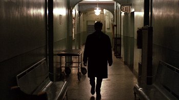 Movie still from “The Godfather” (1972), directed by Francis Ford Coppola – A man walking down a long hallway in a building; Wide shot, High angle