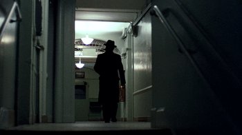 Movie still from “The Godfather” (1972), directed by Francis Ford Coppola – A man standing in a doorway wearing a hat; Wide shot, Low angle