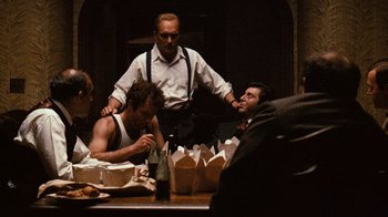 Movie still from “The Godfather” (1972), directed by Francis Ford Coppola – A group of men sitting at a table with food; Medium shot, Over the shoulder angle