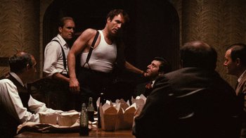 Movie still from “The Godfather” (1972), directed by Francis Ford Coppola – A group of men sitting at a table with food; Medium shot, Over the shoulder angle