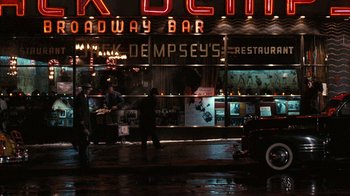 Movie still from “The Godfather” (1972), directed by Francis Ford Coppola – A car parked in front of a building on a rainy night; Extreme Wide shot, High angle