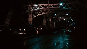 Movie still from “The Godfather” (1972), directed by Francis Ford Coppola – A bridge with lights on the top of it at night; Extreme Wide shot, High angle