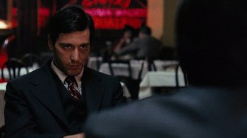 Movie still from “The Godfather” (1972), directed by Francis Ford Coppola – A person wearing a suit and tie; Medium shot, Over the shoulder angle