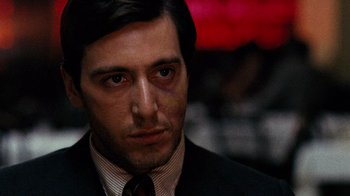Movie still from “The Godfather” (1972), directed by Francis Ford Coppola – A person wearing a suit and tie; Close Up shot, Over the shoulder angle
