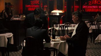 Movie still from “The Godfather” (1972), directed by Francis Ford Coppola – A group of people sitting at a table in a restaurant; Wide shot, Over the shoulder angle