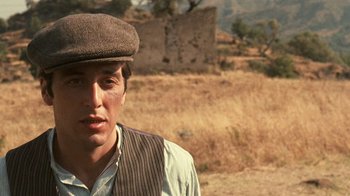 Movie still from “The Godfather” (1972), directed by Francis Ford Coppola – A man wearing a hat standing in the middle of a field; Close Up shot, Low angle