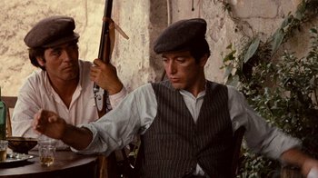 Movie still from “The Godfather” (1972), directed by Francis Ford Coppola – A man holding a rifle in his right hand; Medium shot, Low angle
