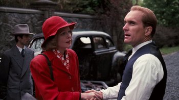 Movie still from “The Godfather” (1972), directed by Francis Ford Coppola – A woman in a red hat and a man in a suit shake hands; Medium shot, Over the shoulder angle