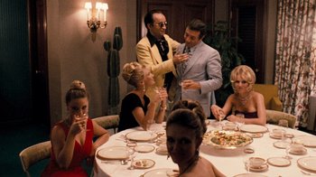 Movie still from “The Godfather” (1972), directed by Francis Ford Coppola – A group of people sitting around a table with plates of food; Medium shot, Over the shoulder angle