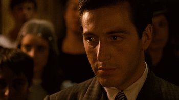 Movie still from “The Godfather” (1972), directed by Francis Ford Coppola – A person wearing a suit and tie; Close Up shot, Over the shoulder angle