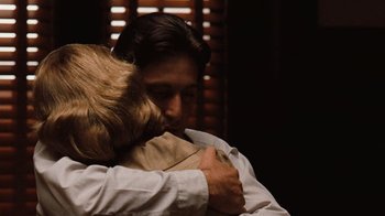 Movie still from “The Godfather” (1972), directed by Francis Ford Coppola – A man and a woman hugging each other in front of a window; Close Up shot, Over the shoulder angle